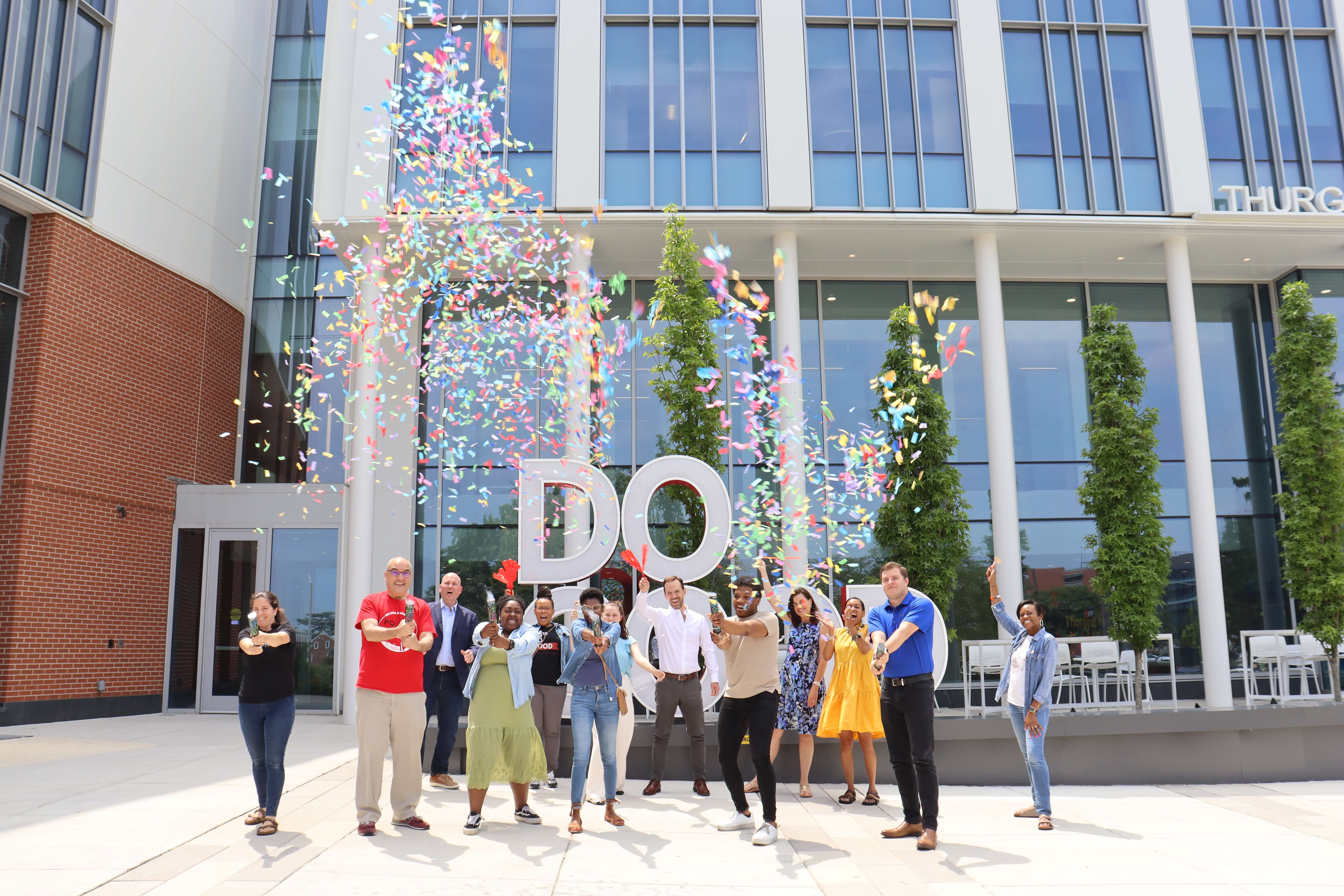 Do Good Sign with employees popping confetti