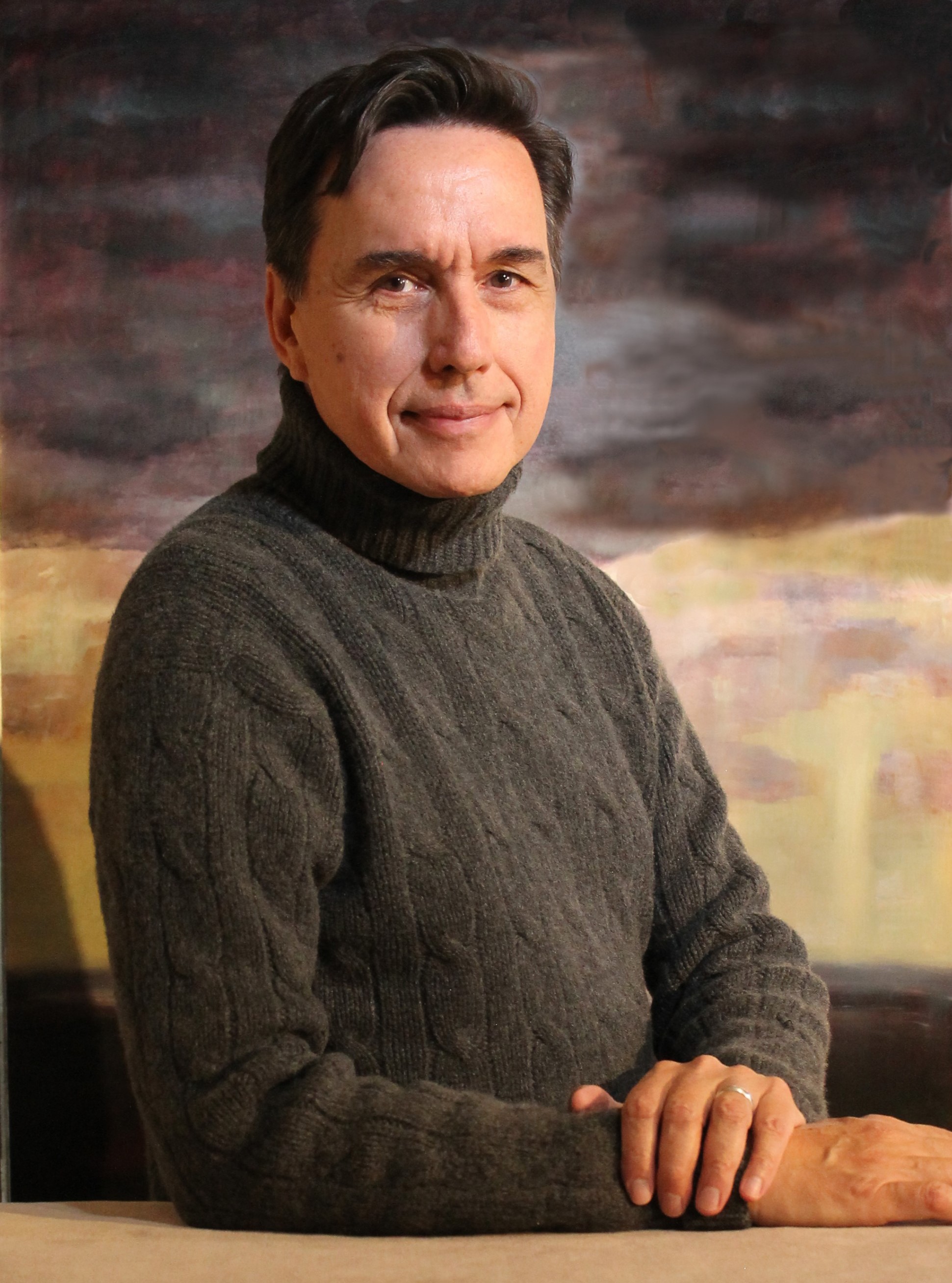 A headshot of Juan Bastos in a gray sweater, head facing ahead and body slanted.